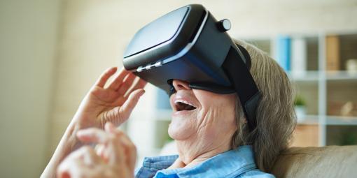 Ältere Dame sieht durch eine Virtual Reality-Brille.