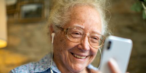 Ältere Frau mit Smartphone und Kopfhörern