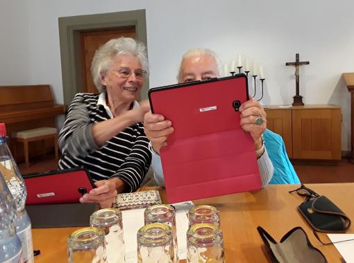 zwei Seniorinnen benutzen gemeinsam ein Tablet