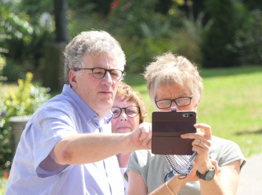 Drei Senioren im Garten machen Fotos mit dem Tablet, Foto-Workshop in Neuwied