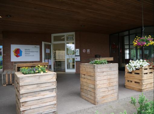 Eingangsbereich des Mehrgenerationenhauses mit Blumenkübeln