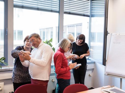 Mehrere Menschen erklären sich gegenseitig Smartphones