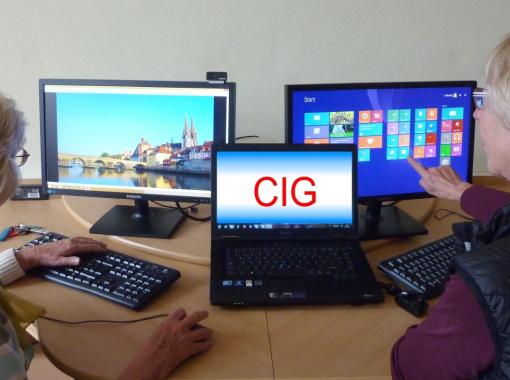 Zwei Personen sitzen vor Laptops.