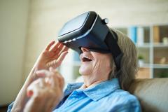 Ältere Dame sieht durch eine Virtual Reality-Brille.