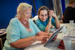 Zwei Frauen sitzen an einem Tablet und lernen