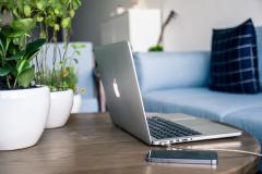 Laptop und Smartphone auf Wohnzimmer-Tisch