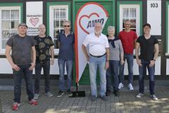 Mitarbeiter des Computertreffs Langenfeld stehen vor dem Eingang mit einer AWO Flagge im Hintergrund