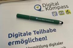 Eine Broschüre mit dem Titel "Digitale Teilhabe ermöglichen!" Ein Stift liegt darauf mit der Aufschrift: www.digital-kompass.de