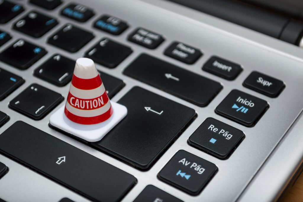 Ein Warnkegel mit der Aufschrift "Caution" für "Achtung" auf einer Tastatur.